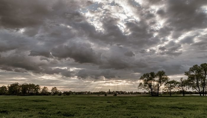 paisagem-dramatica-com-raios-de-sol-brilhando-em-um-ceu-escuro-e-nublado.jpg