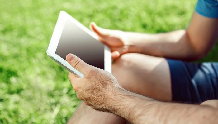 close-up-casual-dressed-young-man-using-modern-digital-tablet-while-sitting-park-hipster-man-connect.jpeg