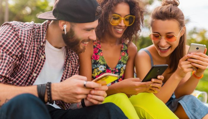 feliz-jovem-companhia-de-amigos-sorridentes-sentados-no-parque-usando-smartphones-homens-e-mulheres.jpeg feliz-jovem-companhia-de-amigos-sorridentes-sentados-no-parque-usando-smartphones-homens-e-mulheres.jpeg