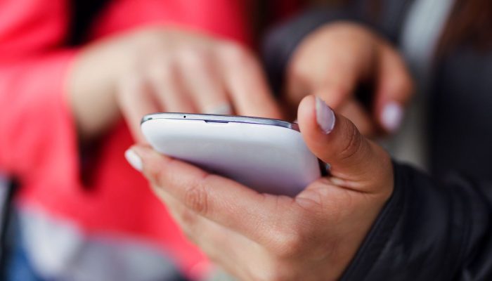 two-beautiful-students-using-mobile-phone-street_0.jpg two-beautiful-students-using-mobile-phone-street_0.jpg