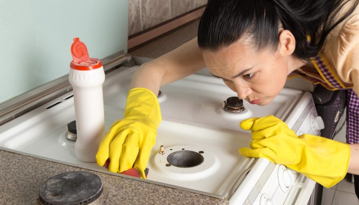 young-housewife-with-yellow-gloves-cleaning-gas-stove.jpg young-housewife-with-yellow-gloves-cleaning-gas-stove.jpg